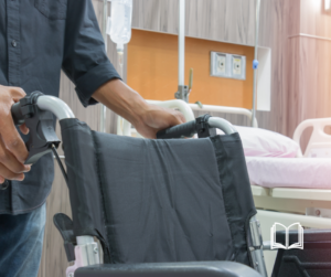 A nurse holding an empty gray wheelchair.