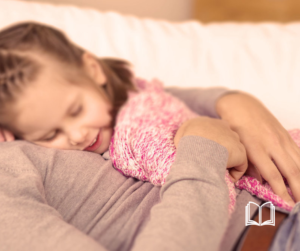 A child sleeping in her mother's arms.