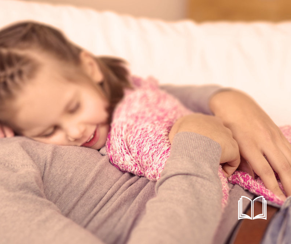 A child sleeping in her mother's arms.