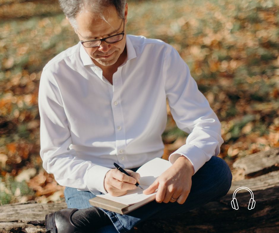 Prof Dr. Jan Bonhoeffer sitting on a ledge while writing in a journal.