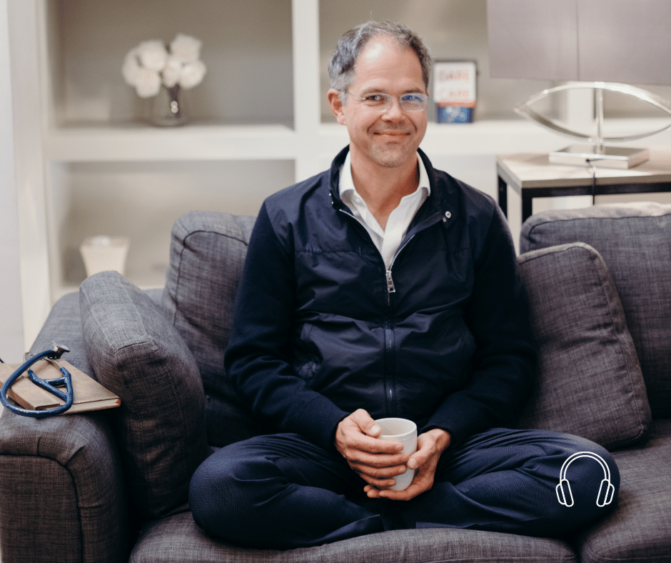 Prof Dr. Jan Bonhoeffer sitting with a glass of water on a gray couch.