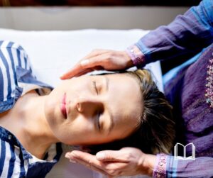 Healer's hands hovering on the side of a patient's head for healing.