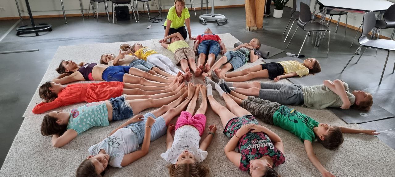 Children lieing down in a circle with their feet towards the centre.